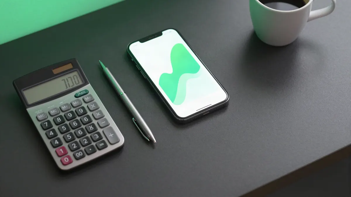 Calculator, pen and phone on a desk, ready for tax planning